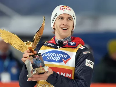 Daniel Tschofenig, of Austria, holds his trophy after winning the 73rd Four Hills ski jumping tournament in Bischofshofen, Austria, Monday, Jan. 6, 2025. (AP Photo/Matthias Schrader)