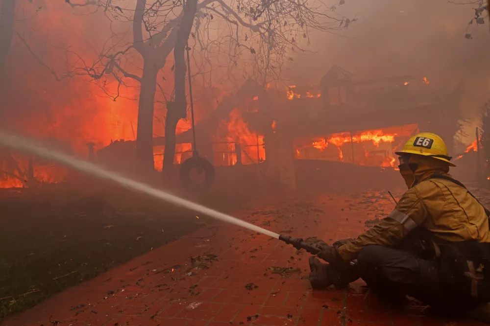 08 January 2025, US, Los Angeles: A firefighter battles a home in flames in Pacific Palisades during the second day of the Palisades fire which has burned more than 15,000 acres and destroyed at least 1,000 structures. At least 5 are dead and thousands have fled their homes as multiple wildfires fueled by Santa Ana winds blast across southern California. Photo: Jonathan Alcorn/ZUMA Press Wire/dpa