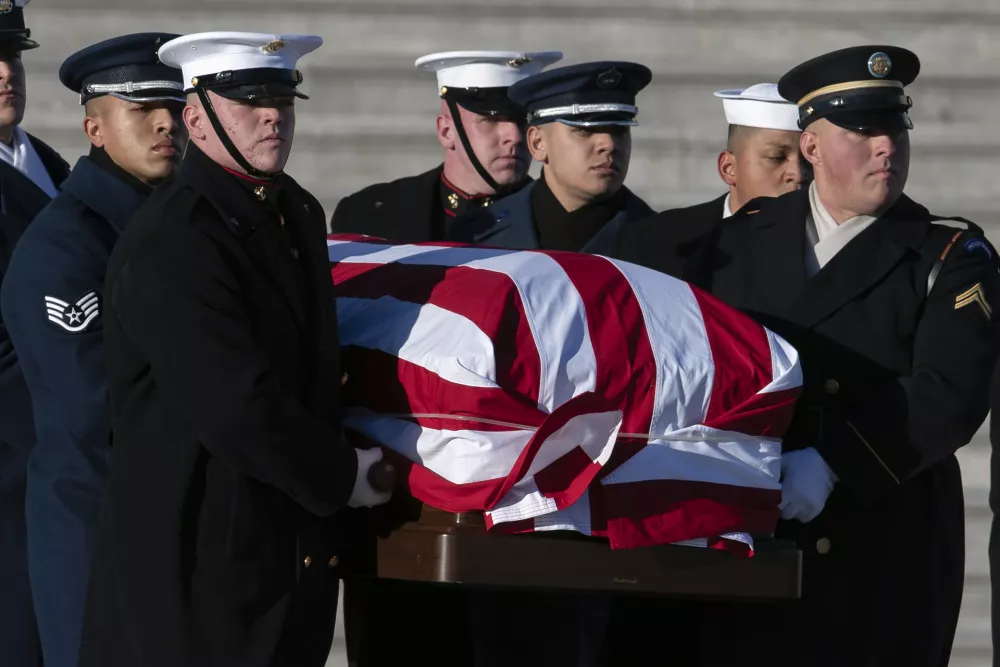 A joint services military body bearer team carries the flag-draped casket of former President Jimmy Carter from the U.S. Capitol on the way to a state funeral at the National Cathedral in Washington, Thursday, Jan. 9, 2025. (AP Photo/Jose Luis Magana)