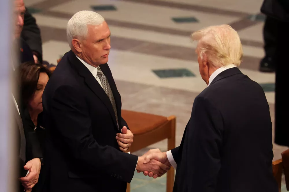 U.S. President-elect Donald Trump shakes hands with former U.S. Vice President Mike Pence on the day of the State Funeral for former U.S. President Jimmy Carter at the Washington National Cathedral in Washington, U.S., January 9, 2025. REUTERS/Brendan McDermid   TPX IMAGES OF THE DAY