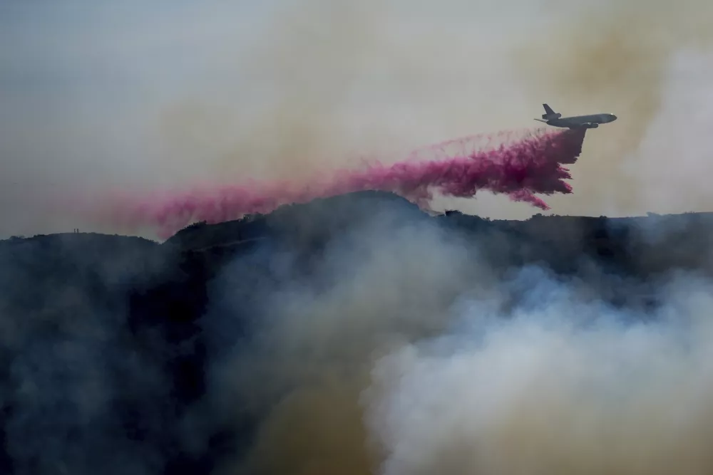 FILE - Fire retardant is dropped by an air tanker on the Palisades Fire in the outskirts of the Pacific Palisades neighborhood of Los Angeles, Jan. 10, 2025. (AP Photo/Eric Thayer, File)