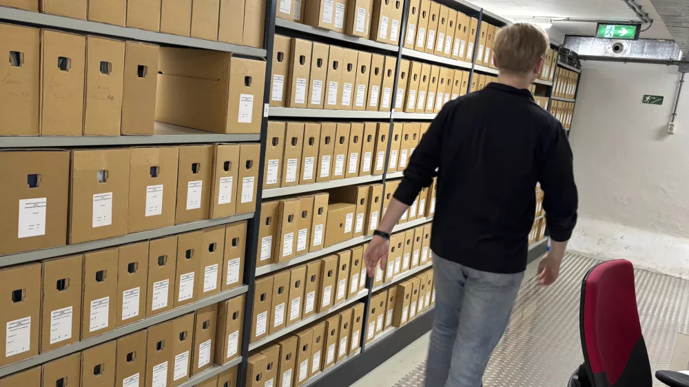 An archivist walks by file cabinets where documents, some regarding WWII collaboration, are stored at the NIOD Institute for War, Holocaust and Genocide Studies in Amsterdam, Netherlands, Friday, Jan. 10, 2025. (AP Photo/Aleks Furtula)