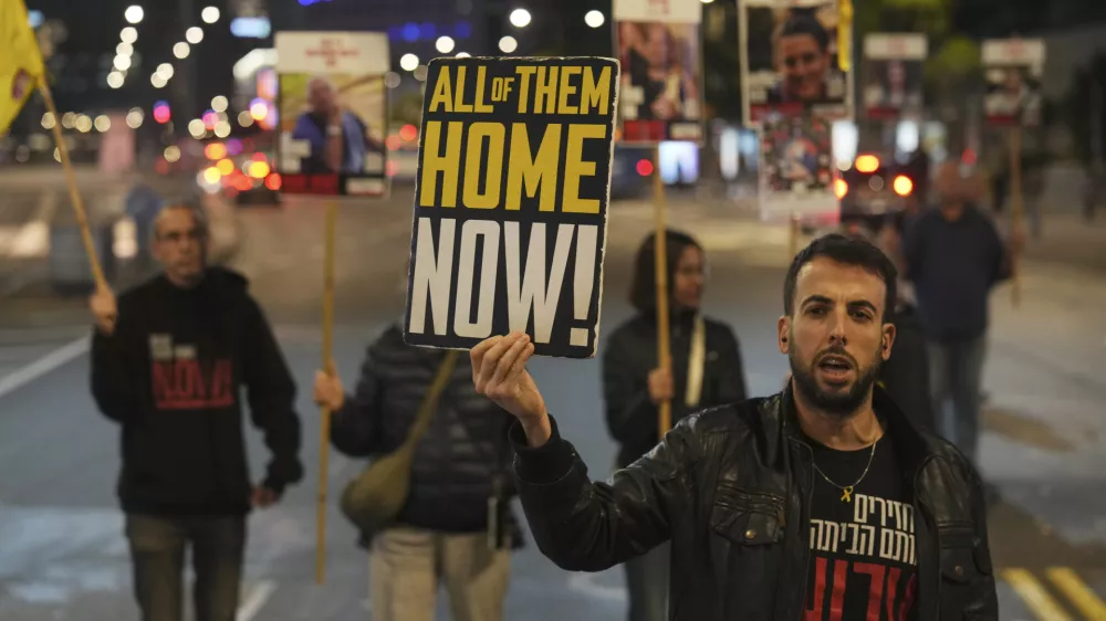 FILE - Israeli protesters call for Hamas to release hostages outside the Ministry of Defense headquarters in Tel Aviv, Israel, on Dec. 17, 2024. (AP Photo/Ariel Schalit, File)