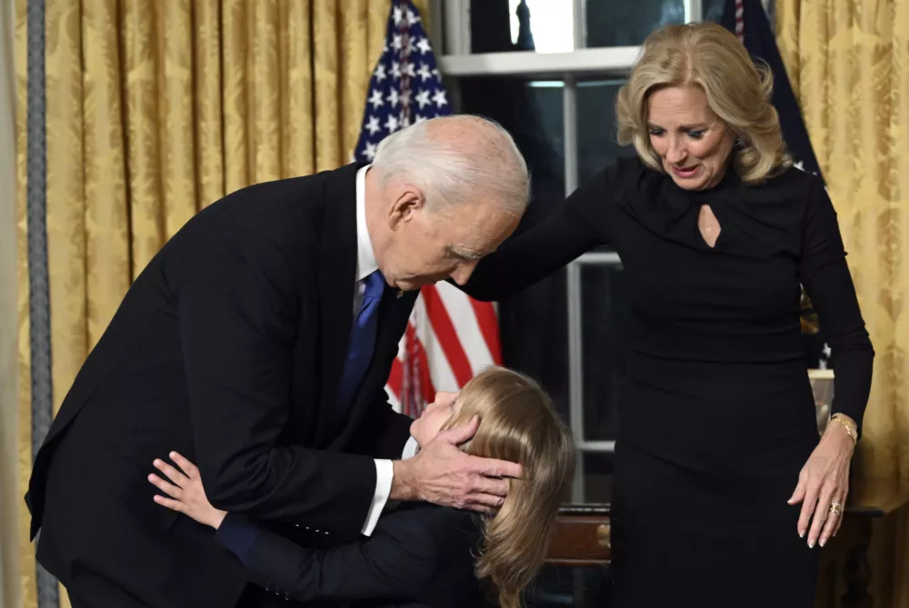 President Joe Biden hugs grandson Beau Biden as first lady Jill Biden watches after he gave his farewell address from the Oval Office of the White House Wednesday, Jan. 15, 2025, in Washington. (Mandel Ngan/Pool via AP)