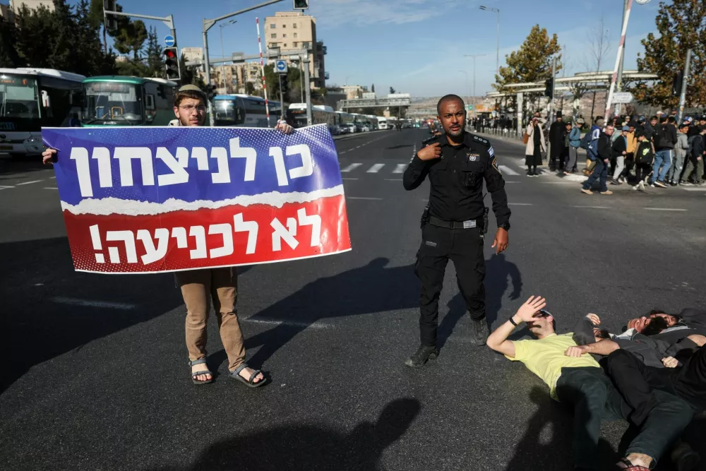 A man holds a banner that reads ''Yes to victory, no to surrender'', as people protest a ceasefire deal that they think may weaken Israel's future security, in Jerusalem, January 16, 2025. REUTERS/Ronen Zvulun