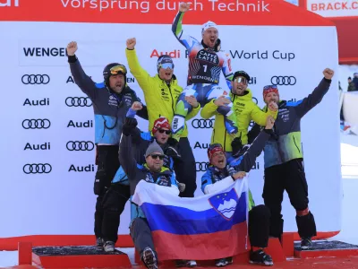 Slovenia's Miha Hrobat, center top, celebrates on the podium with his team after taking third place in an alpine ski, men's World Cup downhill, in Wengen, Switzerland, Saturday, Jan. 18, 2025. (AP Photo/Giovanni Maria Pizzato)