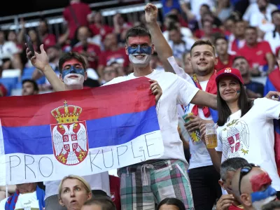 FILE - Fans for Serbia have painted faces and hold a flag in the stands prior to a Group C match between Denmark and Serbia at the Euro 2024 soccer tournament in Munich, Germany, Tuesday, June 25, 2024. (AP Photo/Matthias Schrader, File)