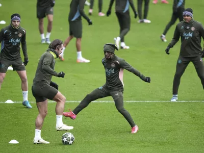 Manchester City's Jack Grealish, front left, and Jeremy Doku, front right, challenge for the ball during a training session in Manchester, England, Monday, Feb. 10, 2025, ahead of the Champions League soccer match between Manchester City and Real Madrid. (Martin Rickett/PA via AP)