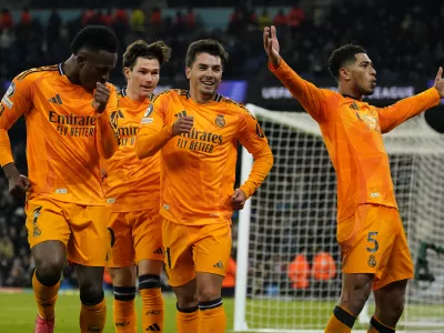 Real Madrid's Jude Bellingham, right, celebrates with teammates after scoring his sides third goal during the Champions League playoff first leg soccer match between Manchester City and Real Madrid at the Etihad Stadium in Manchester, England, Tuesday, Feb. 11, 2025. (AP Photo/Dave Thompson)