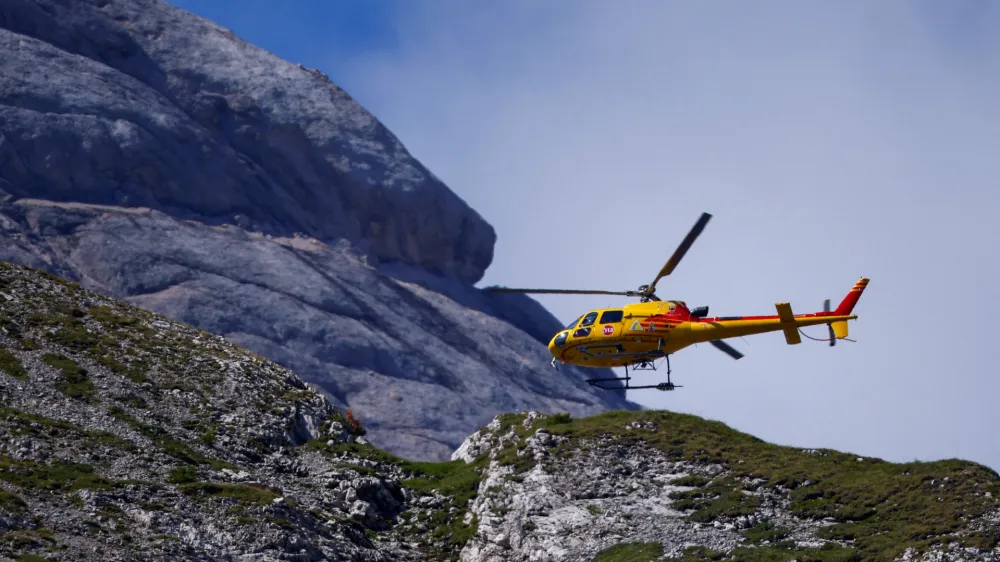 A helicopter participates in a search and rescue operation at the site of a deadly collapse of parts of a mountain glacier in the Italian Alps amid record temperatures, at Marmolada ridge, Italy July 5, 2022. REUTERS/Guglielmo Mangiapane