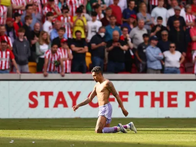 Soccer Football - Premier League - Brentford v Leeds United - Brentford Community Stadium, London, Britain - May 22, 2022 Leeds United's Raphinha celebrates after the match as Leeds United avoid relegation from the Premier League REUTERS/David Klein EDITORIAL USE ONLY. No use with unauthorized audio, video, data, fixture lists, club/league logos or 'live' services. Online in-match use limited to 75 images, no video emulation. No use in betting, games or single club /league/player publications. Please contact your account representative for further details.