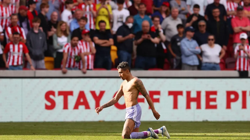 Soccer Football - Premier League - Brentford v Leeds United - Brentford Community Stadium, London, Britain - May 22, 2022 Leeds United's Raphinha celebrates after the match as Leeds United avoid relegation from the Premier League REUTERS/David Klein EDITORIAL USE ONLY. No use with unauthorized audio, video, data, fixture lists, club/league logos or 'live' services. Online in-match use limited to 75 images, no video emulation. No use in betting, games or single club /league/player publications. Please contact your account representative for further details.