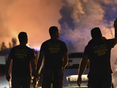 Firefighters watch a wildfire burning near Zaton, Croatia, Wednesday, July 13, 2022. Fueled by strong winds, fires raged at Croatia's Adriatic Sea, with the most dramatic situation reported near the town of Sibenik, where water-dropping planes and dozens of firefighters struggled to contain the flames that briefly engulfed some cars and the church tower in the Zaton area on the outskirts of the town before firefighters managed to put it out. (AP Photo)