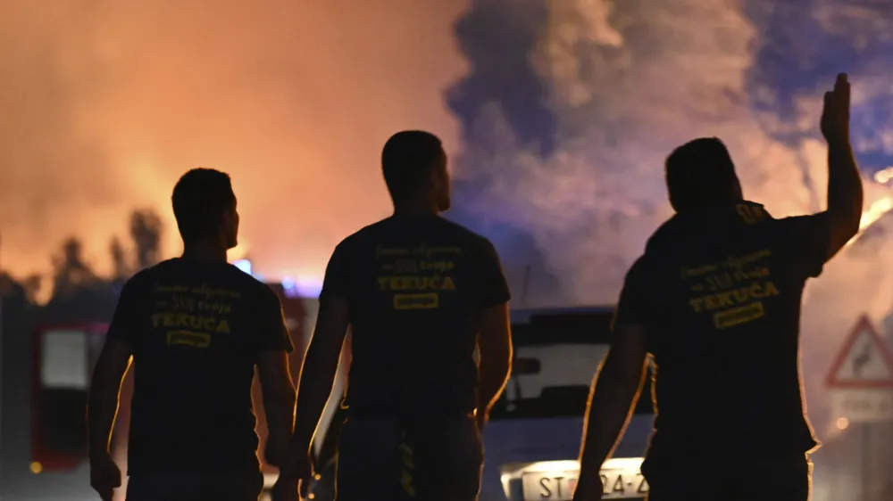 Firefighters watch a wildfire burning near Zaton, Croatia, Wednesday, July 13, 2022. Fueled by strong winds, fires raged at Croatia's Adriatic Sea, with the most dramatic situation reported near the town of Sibenik, where water-dropping planes and dozens of firefighters struggled to contain the flames that briefly engulfed some cars and the church tower in the Zaton area on the outskirts of the town before firefighters managed to put it out. (AP Photo)