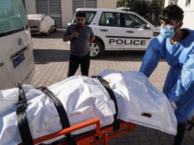 20 July 2022, Iraq, Zakho: A medic transports the body of a victim killed in a Turkish shelling on a tourist resort in northern Iraq. At least eight civilians were killed and 20 others injured in a Turkish artillery shelling that struck a tourist resort in the village of Parakh in the Kurdish province of Duhok. Photo: Ismael Adnan/dpa