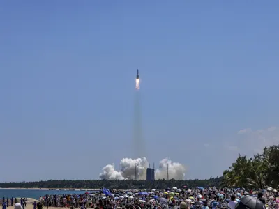 In this photo released by Xinhua News Agency, people gather at the beach side as they watch the Long March 5B Y3 carrier rocket, carrying Wentian lab module, lift off from the Wenchang Space Launch Center in Wenchang in southern China's Hainan Province Sunday, July 24, 2022. On a hot Sunday afternoon, with a large crowd of amateur photographers and space enthusiasts watching, China launched the Wentian lab module from tropical Hainan Island. (Zhang Liyun/Xinhua via AP)