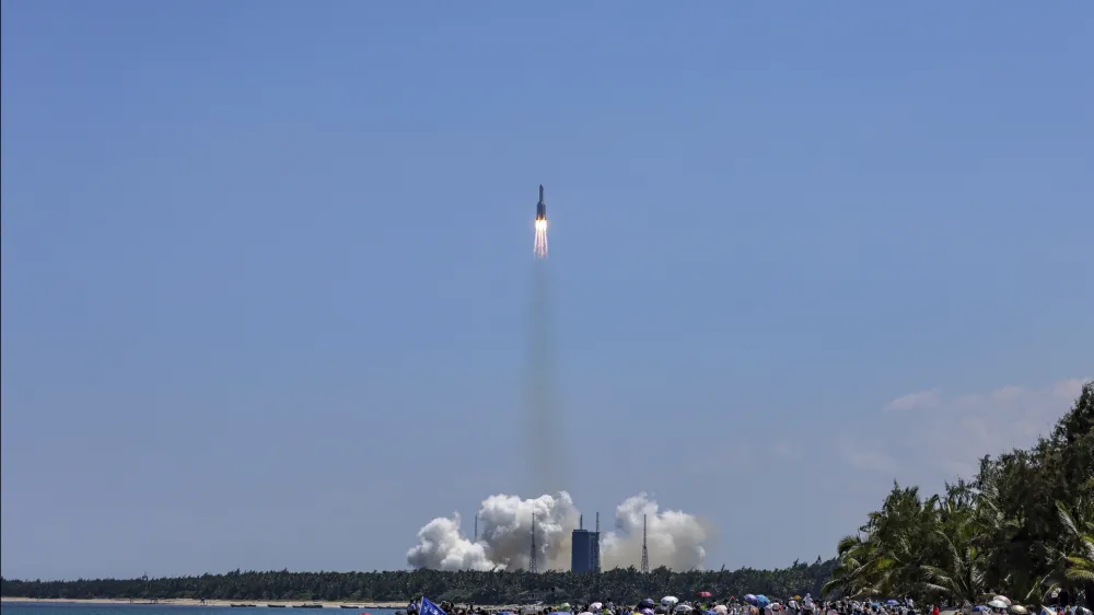 In this photo released by Xinhua News Agency, people gather at the beach side as they watch the Long March 5B Y3 carrier rocket, carrying Wentian lab module, lift off from the Wenchang Space Launch Center in Wenchang in southern China's Hainan Province Sunday, July 24, 2022. On a hot Sunday afternoon, with a large crowd of amateur photographers and space enthusiasts watching, China launched the Wentian lab module from tropical Hainan Island. (Zhang Liyun/Xinhua via AP)