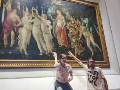 Two activists of Ultima Generazione (Last Generation) environmentalist group claim to glue themselves to the glass protecting Italian Renaissance painter Sandro Botticelli's Primavera (Spring) in Florence's Uffizi Galleries, central Italy, Friday, July 22, 2022. Carabinieri police said two Italian young women and a man sat on the floor in the Uffizi's Botticelli room and displayed a banner reading, "Last Generation No Gas No Coal". The museum said thanks to the glass the masterpiece was unharmed. (Ultima Generation via AP)(Ultima Generation via AP)