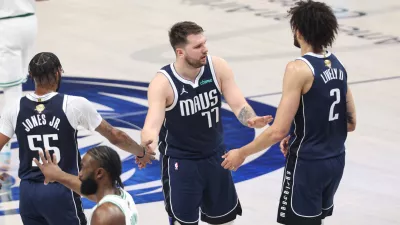 Jun 14, 2024; Dallas, Texas, USA; Dallas Mavericks guard Luka Doncic (77) high fives center Dereck Lively II (2) and forward Derrick Jones Jr. (55) during the first quarter against the Boston Celtics during game four of the 2024 NBA Finals at American Airlines Center. Mandatory Credit: Kevin Jairaj-USA TODAY Sports