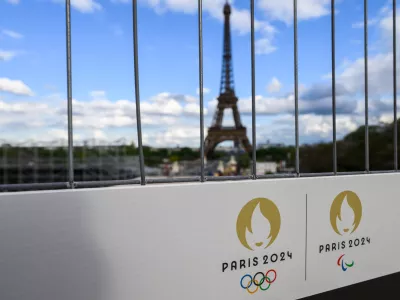 FILED - 06 May 2024, France, Paris: The Olympic rings and the Paralympic Games logo can be seen on a sign on a construction fence in front of the Eiffel Tower. Photo: Robert Michael/dpa