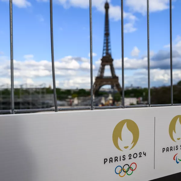 FILED - 06 May 2024, France, Paris: The Olympic rings and the Paralympic Games logo can be seen on a sign on a construction fence in front of the Eiffel Tower. Photo: Robert Michael/dpa