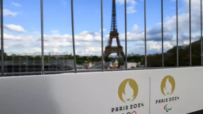 FILED - 06 May 2024, France, Paris: The Olympic rings and the Paralympic Games logo can be seen on a sign on a construction fence in front of the Eiffel Tower. Photo: Robert Michael/dpa