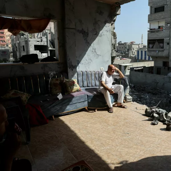 People sit at a ruined building, in the aftermath of Israeli strikes at the area where Israeli hostages were rescued, amid the Israel-Hamas conflict, in Nuseirat refugee camp, central Gaza Strip, June 15, 2024. REUTERS/Ramadan Abed