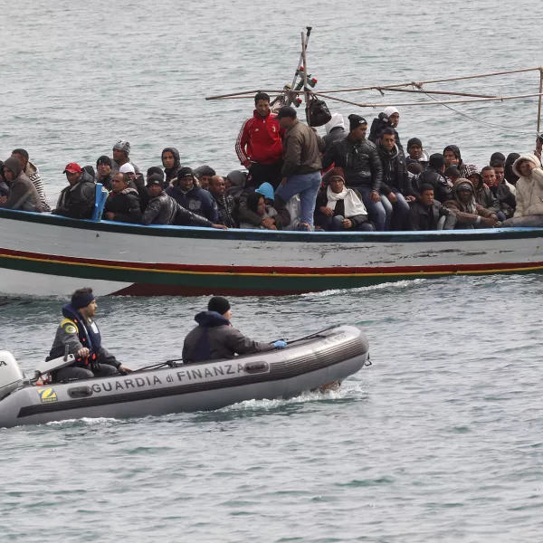 Migrants from North Africa arrive, escorted by Italian Guardia di Finanza, at the southern Italian island of Lampedusa March 14, 2011. Thousands of Tunisians have fled this year in the wake of the uprising that toppled long-time ruler Zine al-Abidine Ben Ali and sparked a wave of upheaval across North Africa and the Middle East. REUTERS/Stefano Rellandini (ITALY - Tags: POLITICS SOCIETY)