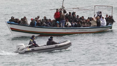 Migrants from North Africa arrive, escorted by Italian Guardia di Finanza, at the southern Italian island of Lampedusa March 14, 2011. Thousands of Tunisians have fled this year in the wake of the uprising that toppled long-time ruler Zine al-Abidine Ben Ali and sparked a wave of upheaval across North Africa and the Middle East. REUTERS/Stefano Rellandini (ITALY - Tags: POLITICS SOCIETY)