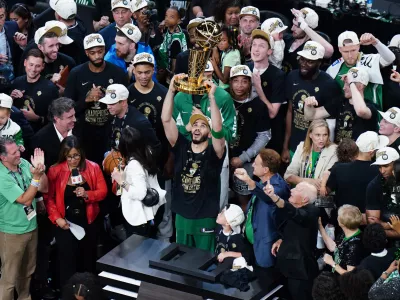 Jun 17, 2024; Boston, Massachusetts, USA; Boston Celtics forward Jayson Tatum (0) celebrates with the trophy on the podium after defeating the Dallas Mavericks in the 2024 NBA Finals at TD Garden. Mandatory Credit: David Butler II-USA TODAY Sports