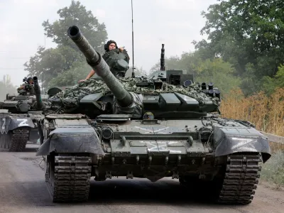 Service members of pro-Russian troops drive tanks in the course of Ukraine-Russia conflict near the settlement of Olenivka in the Donetsk region, Ukraine July 29, 2022. REUTERS/Alexander Ermochenko