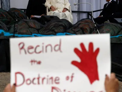 A person holds a protest sign as Pope Francis attends an event at Nakasuk School, in Iqaluit, Canada July 29, 2022. REUTERS/Guglielmo Mangiapane   TPX IMAGES OF THE DAY