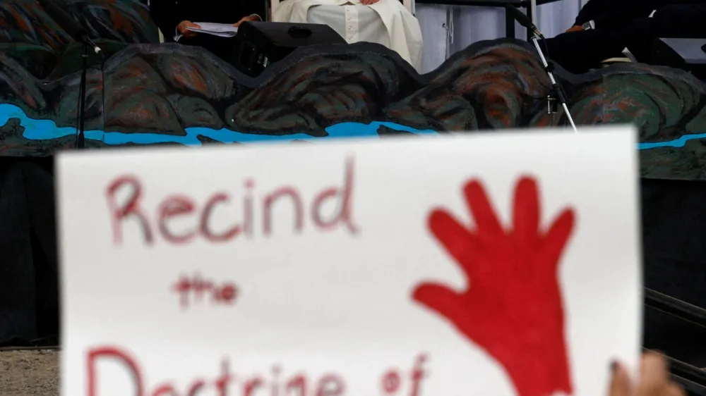 A person holds a protest sign as Pope Francis attends an event at Nakasuk School, in Iqaluit, Canada July 29, 2022. REUTERS/Guglielmo Mangiapane   TPX IMAGES OF THE DAY