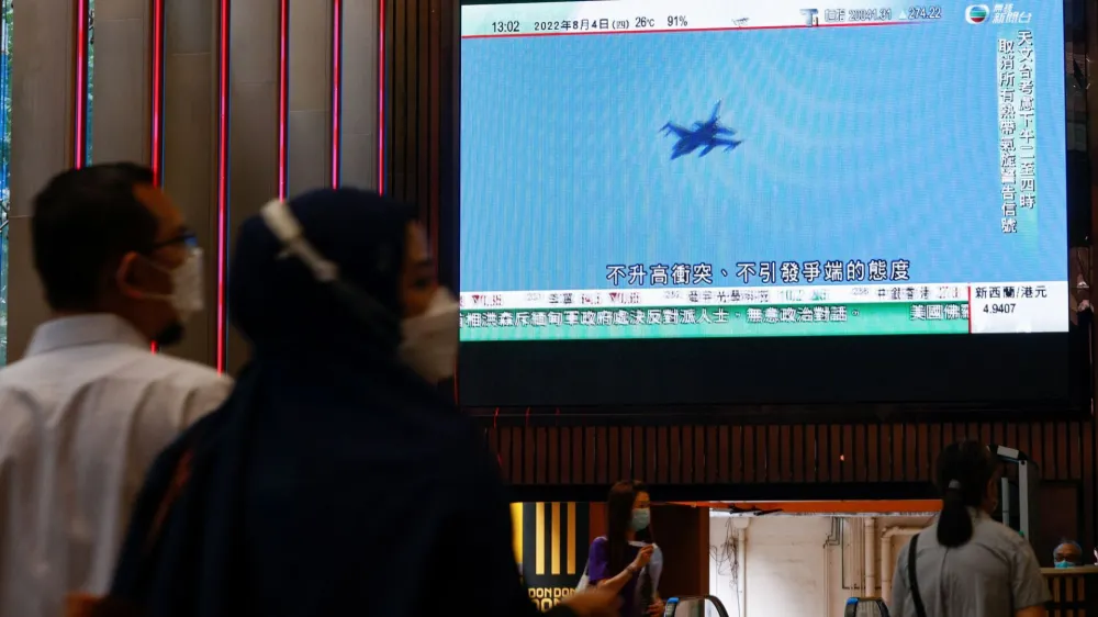 A TV screen shows that China's People's Liberation Army has begun military exercises including live firing on the waters and in the airspace surrounding the island of Taiwan, as reported by Chinese state television, in Hong Kong, China August 4, 2022. REUTERS/Tyrone Siu