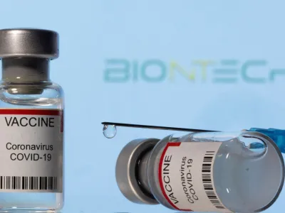 FILE PHOTO: Vials labelled "VACCINE Coronavirus COVID-19" and a syringe are seen in front of a displayed Biontech logo in this illustration taken December 11, 2021. REUTERS/Dado Ruvic/Illustration/File Photo