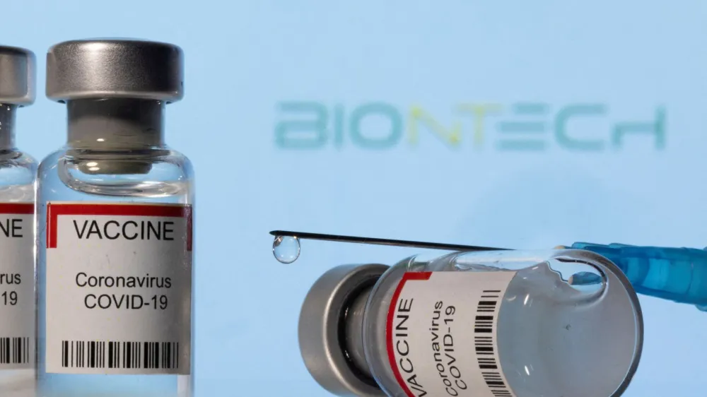 FILE PHOTO: Vials labelled "VACCINE Coronavirus COVID-19" and a syringe are seen in front of a displayed Biontech logo in this illustration taken December 11, 2021. REUTERS/Dado Ruvic/Illustration/File Photo