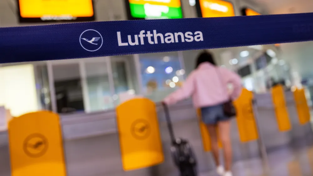 27 July 2022, Bavaria, Munich: A passenger waits at a Lufthansa service counter at Munich Airport. German services trade union Verdi is calling out ground staff at Munich airport on a token strike next week in support of demands for a considerable pay rise, following a successful strike by Lufthansa ground staff two weeks ago. Photo: Peter Kneffel/dpa