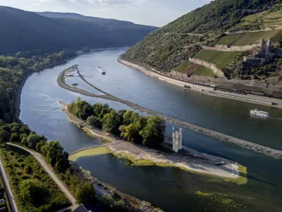 The "Maeuseturm" (mice tower) is pictured in the middle of the river Rhine in Bingen, Germany, Friday, Aug. 12, 2022. The Rhine carries low water after a long drought period. (AP Photo/Michael Probst)