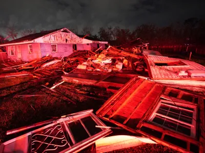 Destroyed homes, illuminated by fire engine lights, are seen after a tornado struck the area in Arabi, La., Tuesday, March 22, 2022. A tornado tore through parts of New Orleans and its suburbs Tuesday night, ripping down power lines and scattering debris in a part of the city that had been heavily damaged by Hurricane Katrina 17 years ago. (AP Photo/Gerald Herbert)