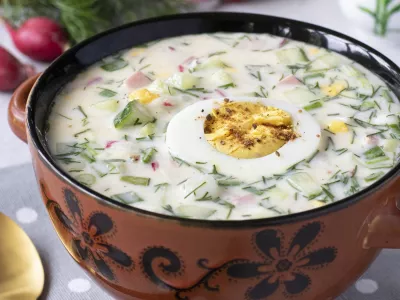 Traditional cold soup okroshka with sausage, radish, green onion and kefir served with boiled egg, Vertical format / Foto: Angelika Mostova