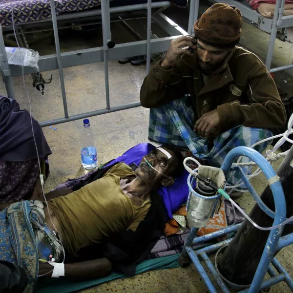 A patient is surrounded by relatives as he takes oxygen and saline while being treated in a hospital after drinking toxic alcohol in Diamond Harbour, near Kolkata, India, Thursday, Dec. 15, 2011. A tainted batch of bootleg liquor has killed scores and sent dozens more to the hospital in villages outside Kolkata, officials said. (AP Photo/Bikas Das)