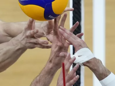 Kevin Tillie, right, of France, tries control the ball against Tobias Brand, left, and Tobias Krick, of Germany during their Volleyball Men's Nations League match at the Mall of Asia Arena in Manila, Philippines on Wednesday, June 19, 2024. (AP Photo/Aaron Favila)