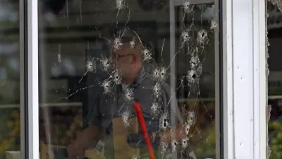 Damage can be seen to a front window law enforcement officers work the scene of a shooting at the Mad Butcher grocery store in Fordyce, Ark., Friday, June 21, 2024. (Colin Murphey/Arkansas Democrat-Gazette via AP)