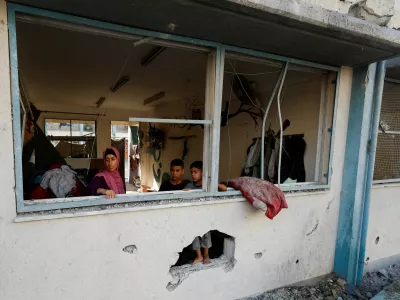 Palestinians stand near the damaged windows of a classroom in a UNRWA school, after the air strike on a neighbouring house to the school in Khan Younis, in the southern Gaza Strip, June 21, 2024. REUTERS/Mohammed Salem