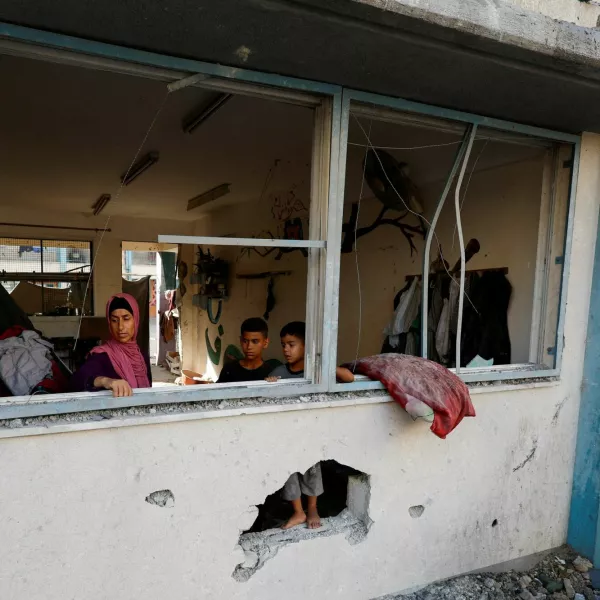 Palestinians stand near the damaged windows of a classroom in a UNRWA school, after the air strike on a neighbouring house to the school in Khan Younis, in the southern Gaza Strip, June 21, 2024. REUTERS/Mohammed Salem