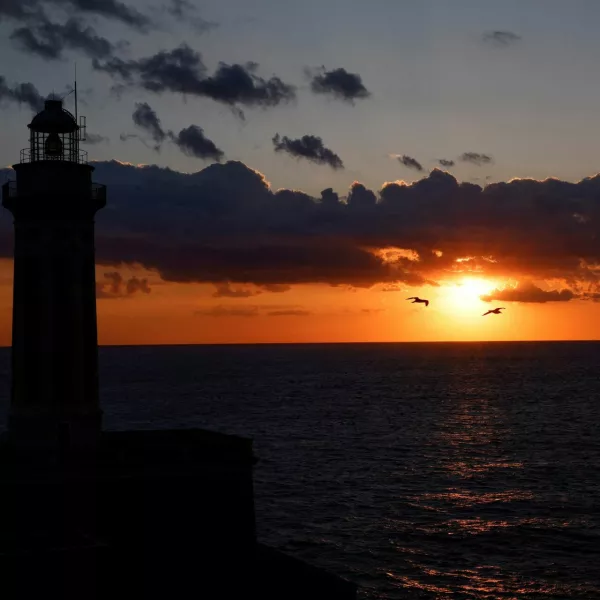 FILE PHOTO: A silhouette of a lighthouse is seen at sunset on Capri island, Italy, April 19, 2024. REUTERS/Remo Casilli/File Photo