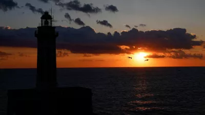 FILE PHOTO: A silhouette of a lighthouse is seen at sunset on Capri island, Italy, April 19, 2024. REUTERS/Remo Casilli/File Photo