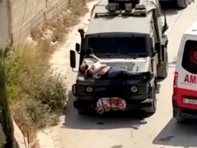 Israeli army straps Palestinian on military jeep during raid in Jenin, in this screengrab from a video, in the Israeli-occupied West Bank, June 22, 2024. REUTERS/Reuters TV