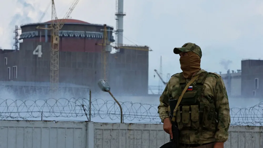 A serviceman with a Russian flag on his uniform stands guard near the Zaporizhzhia Nuclear Power Plant in the course of Ukraine-Russia conflict in the Russian-controlled city of Enerhodar in the Zaporizhzhia region, Ukraine August 4, 2022. REUTERS/Alexander Ermochenko