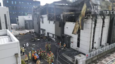 Firefighters carry a body at the site of a fire at a lithium battery manufacturing factory in Hwaseong, South Korea, Monday, June 24, 2024. (Newsis via AP)